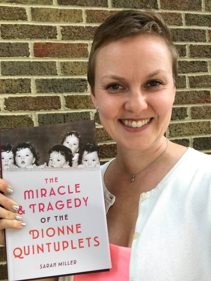 Author Sarah Miller holds a copy of her new book "The Miracle and Tragedy of the Dionne Quintuplets"